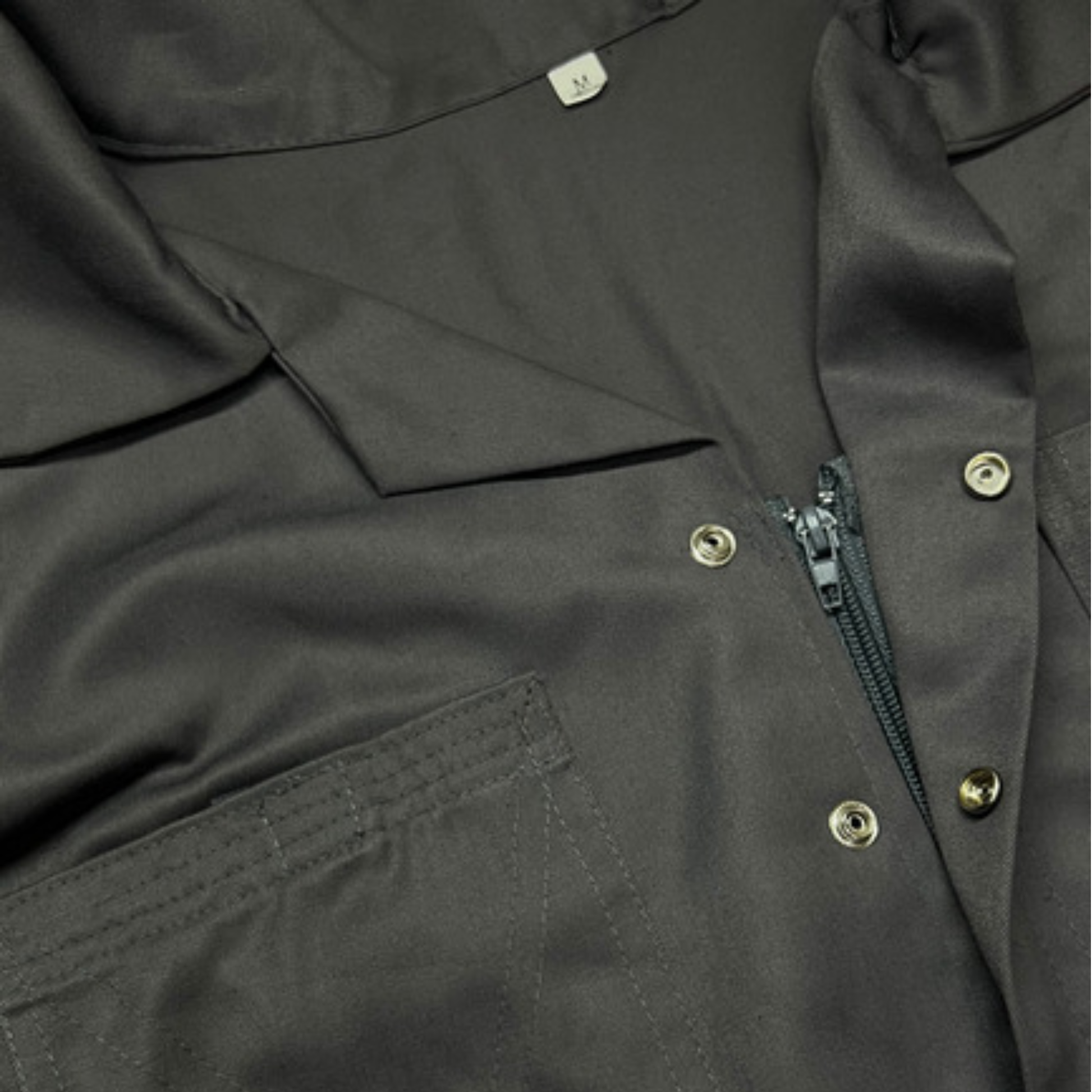 Close-up of a gray coverall with zippers and buttons